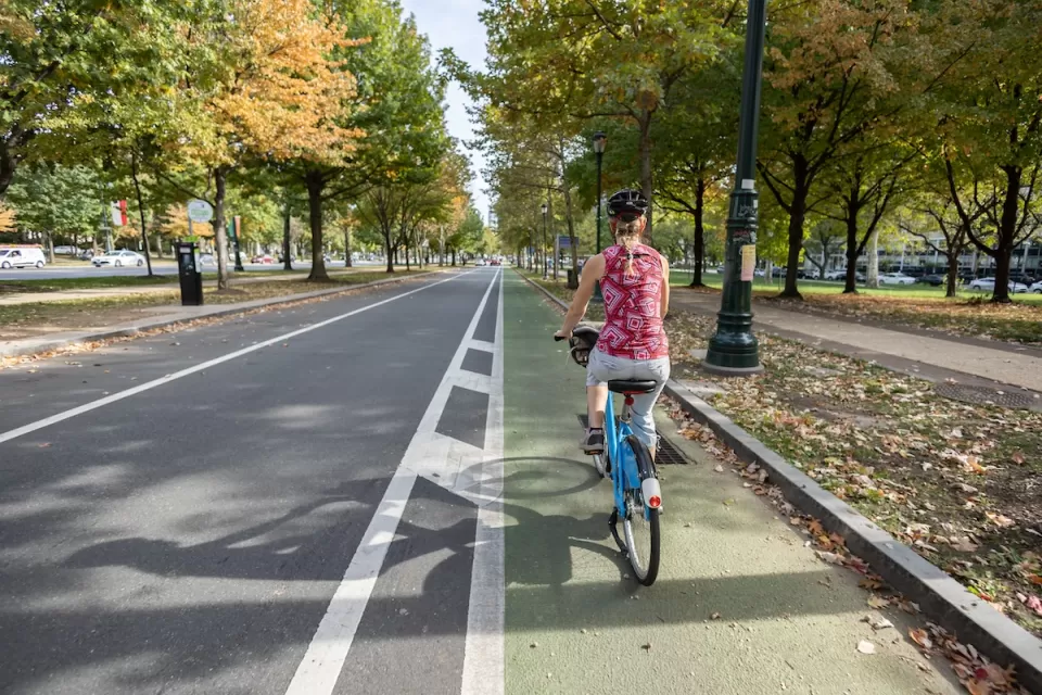 Woman rides a bike in green painted bike lane in Philadelphia, Pennsylvania.